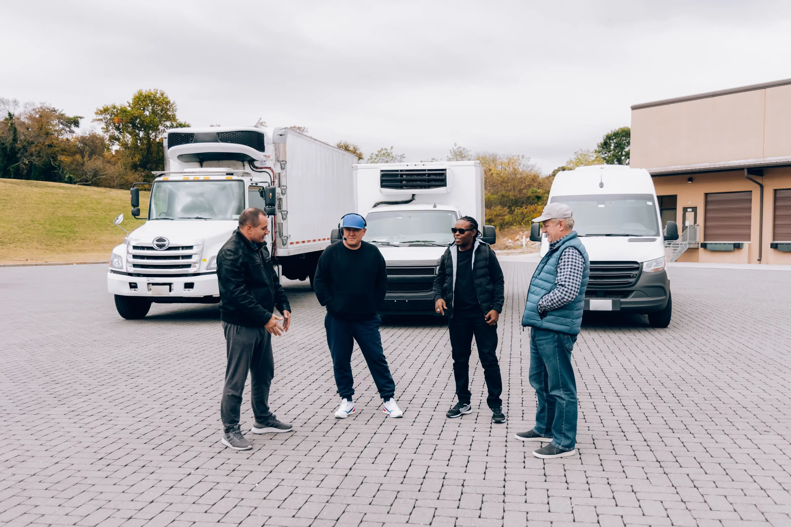 four drivers in front of straight truck box truck and sprinter van scaled